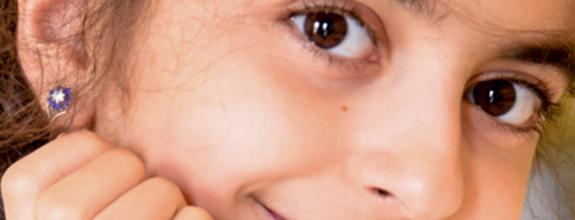 A smiling girl with big brown eyes and dark hair